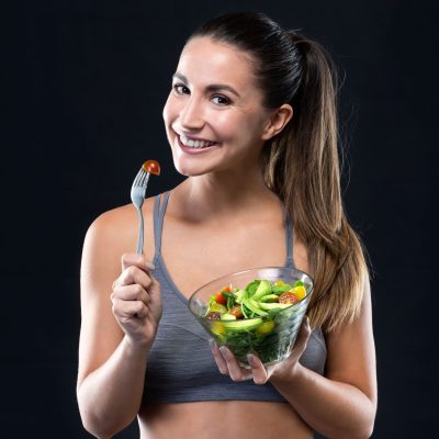 beautiful-young-woman-eating-salad-black-background-1-1-1-scaled.jpg